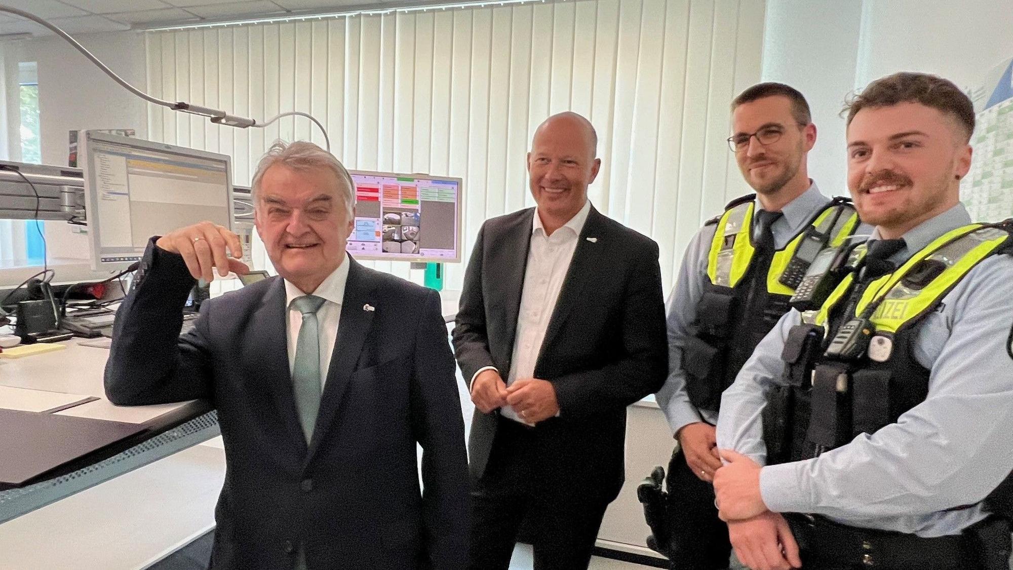 Das Bild zeigt NRW-Innenminister Herbert Reul und Landrat Frank Rock sowie zwei Polizeibeamte in der neuen Wache in Lechenich.