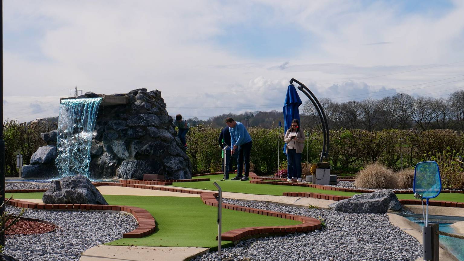Das Bild zeigt eine moderne Minigolf-Anlage mit Kunstrasen.