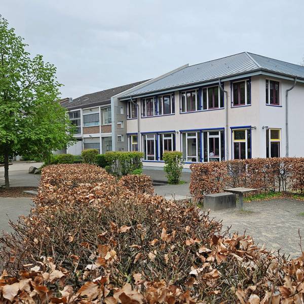 Im Bild die Gesamtschule, davor ein leerer Schulhof.