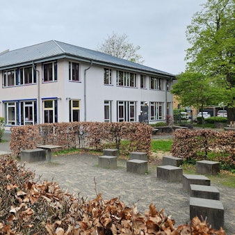Im Bild die Gesamtschule, davor ein leerer Schulhof.