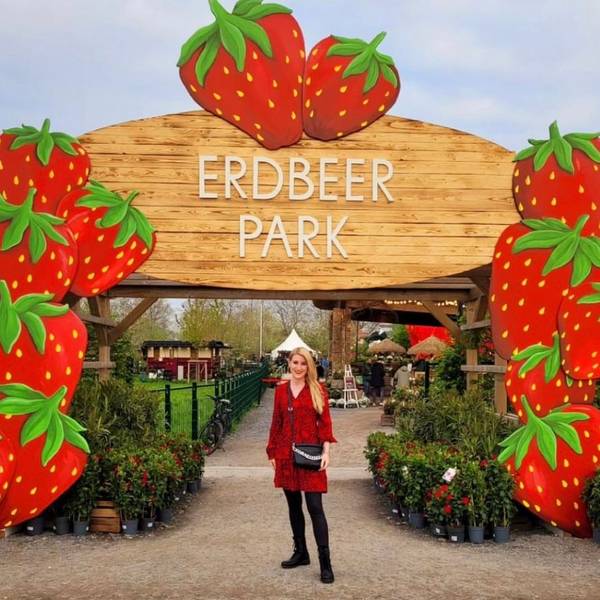Auf dem Foto ist eine Besucherin vor einem Bogen aus überdimensionalen Erdbeeren zu sehen.