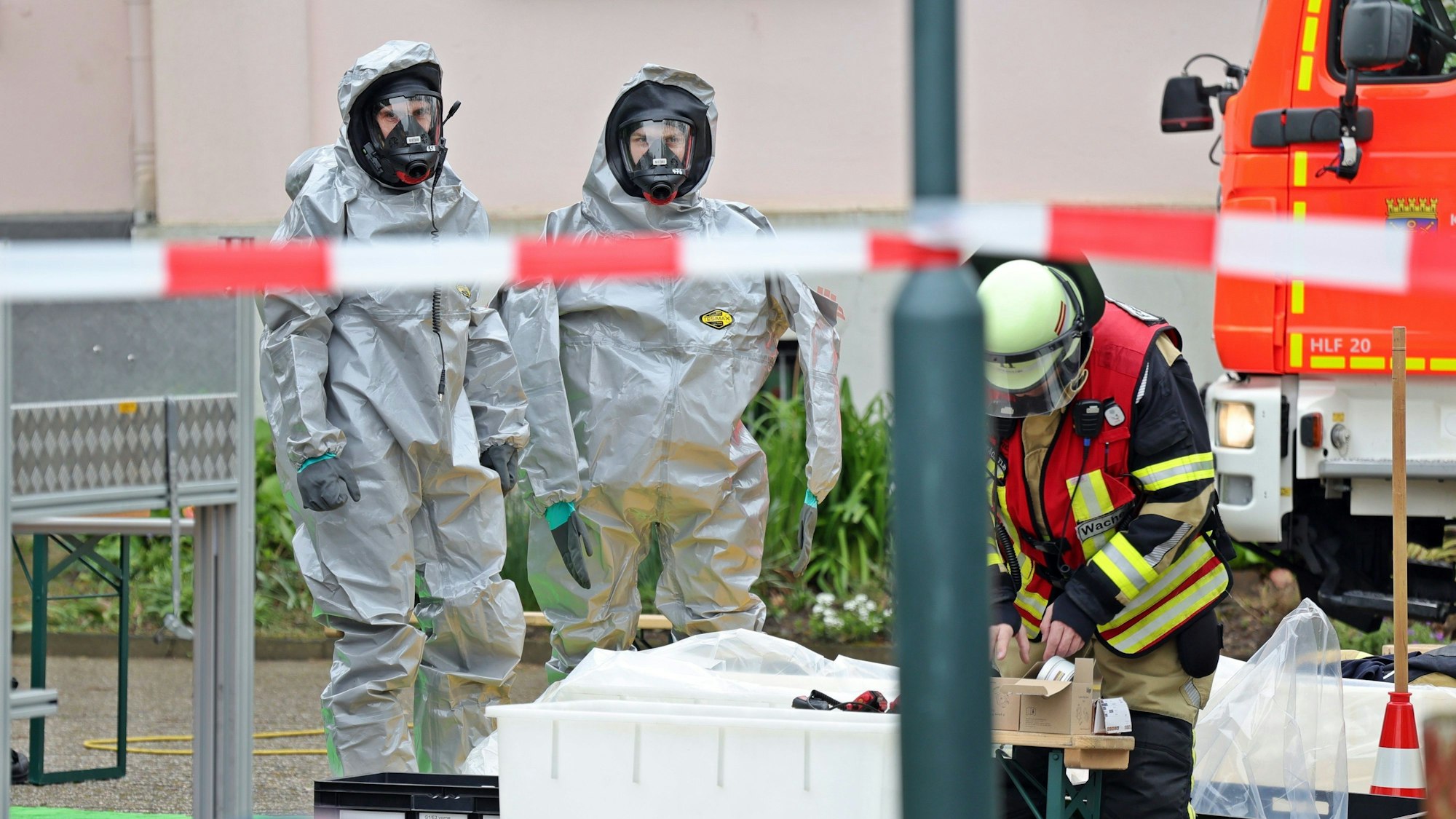 12.04.2024, Nordrhein-Westfalen, Solingen: Kräfte der Feuerwehr sind zum Teil in speziellen Schutzanzügen bei einem Austritt von Chlorlauge in der Schwimmhalle einer Schule im Einsatz. Ein technischer Defekt an einer Pumpe soll nach ersten Erkenntnissen dazu geführt haben. Der Unterricht wurde am Morgen beendet. (zu dpa/lnw «Chlorlauge in Schwimmhalle ausgetreten») Foto: Gianni Gattus/dpa +++ dpa-Bildfunk +++