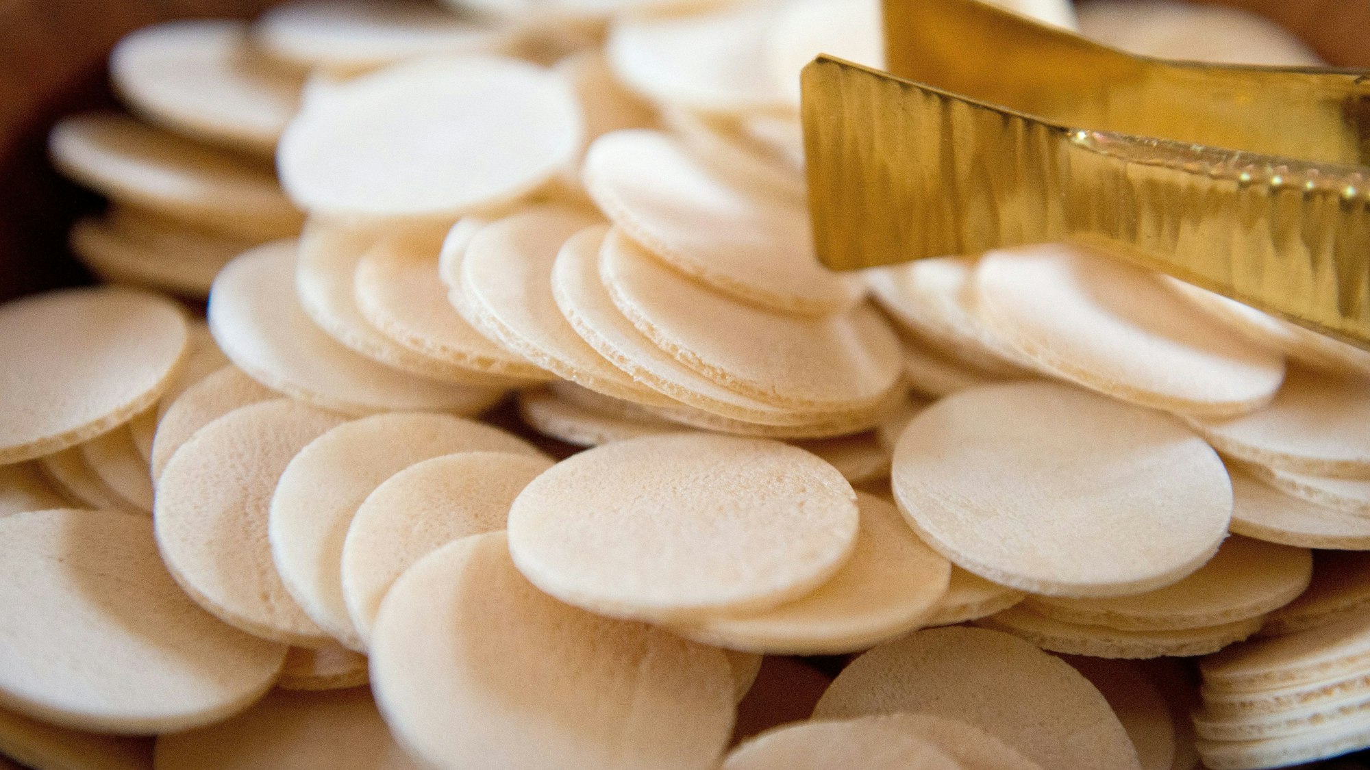 Hostien liegen in einer Schale. In der Hostie ist nach katholischer Auffassung Jesus Christus gegenwärtig.