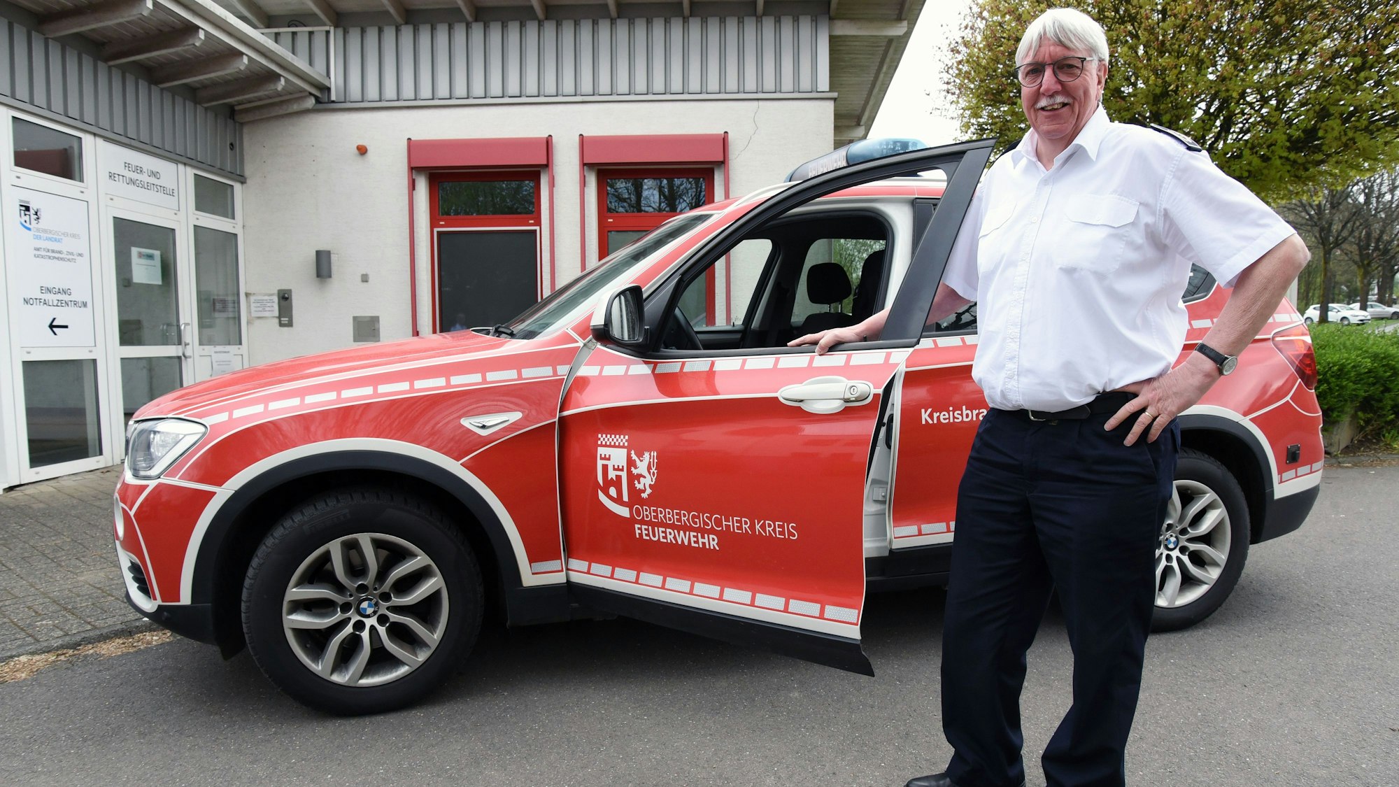 Der scheidende Kreisbrandmeister Wilfried Fischer steht an einem Einsatzwagen vor der Leitstelle des Oberbergischen Kreises in Gummersbach.