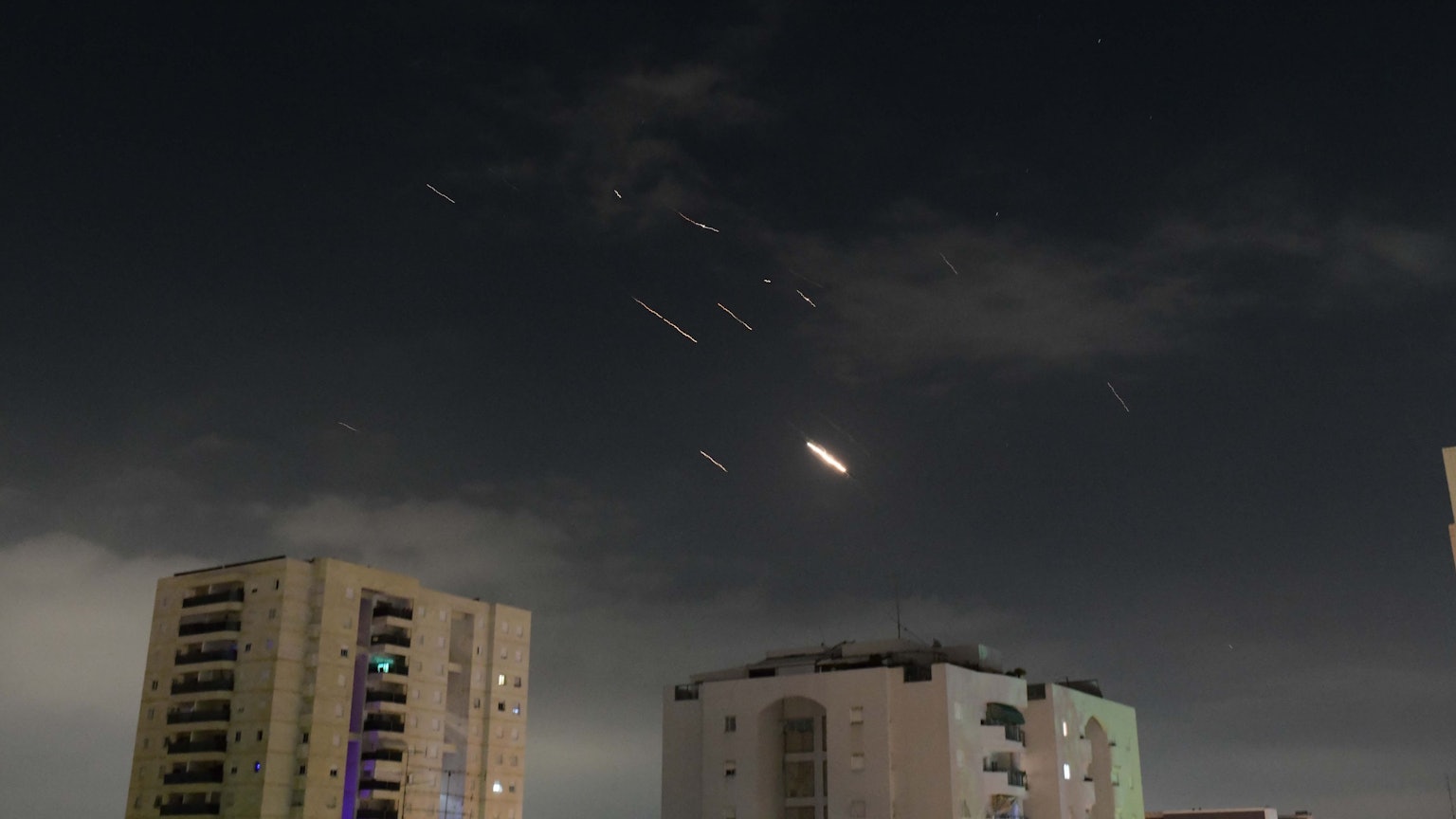 14.04.2024, Israel, Tel Aviv: Flammen von Explosionen erscheinen am Himmel über Tel Aviv, während Israels Raketenabwehrsystem Raketen und Drohnen aus dem Iran abfängt.