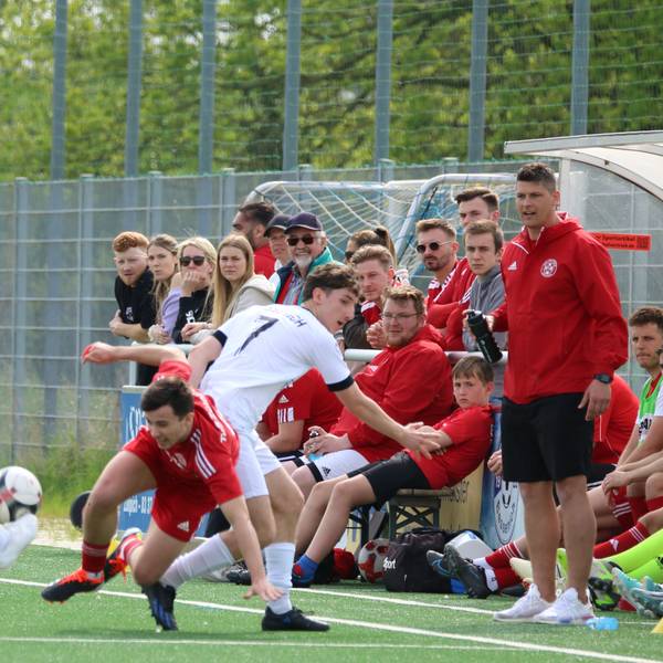 Ein Zülpicher Spieler wird direkt vor der Bank seiner Mannschaft gefoult. Ein weiterer Gegenspieer gelangt so an den Ball.