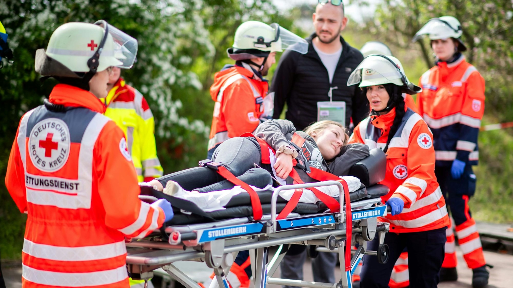 Das Bild zeigt Mitarbeiterinnen des Deutschen Roten Kreuz beim Abtransport einer verletzten Frau.