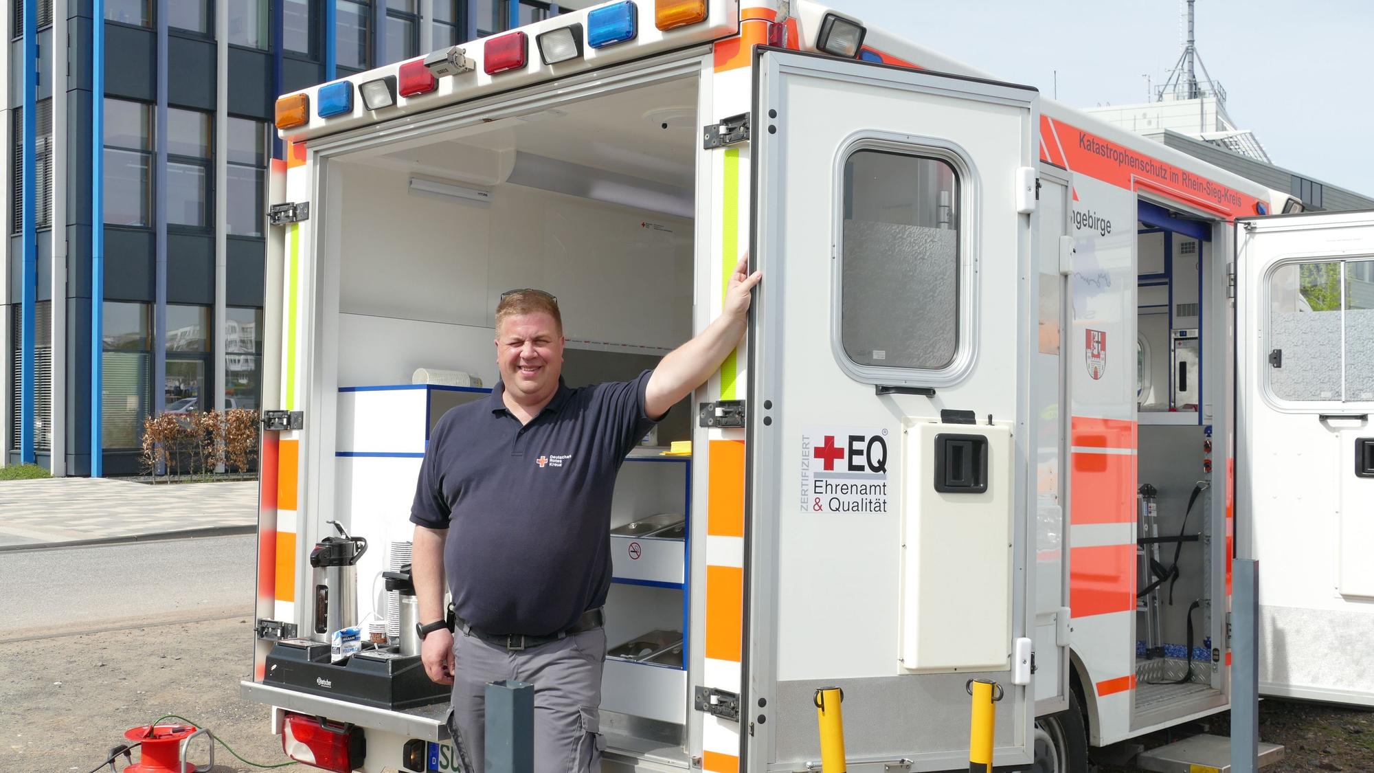 Ein Mann steht vor den geöffneten Türen eines Rettungswagens.