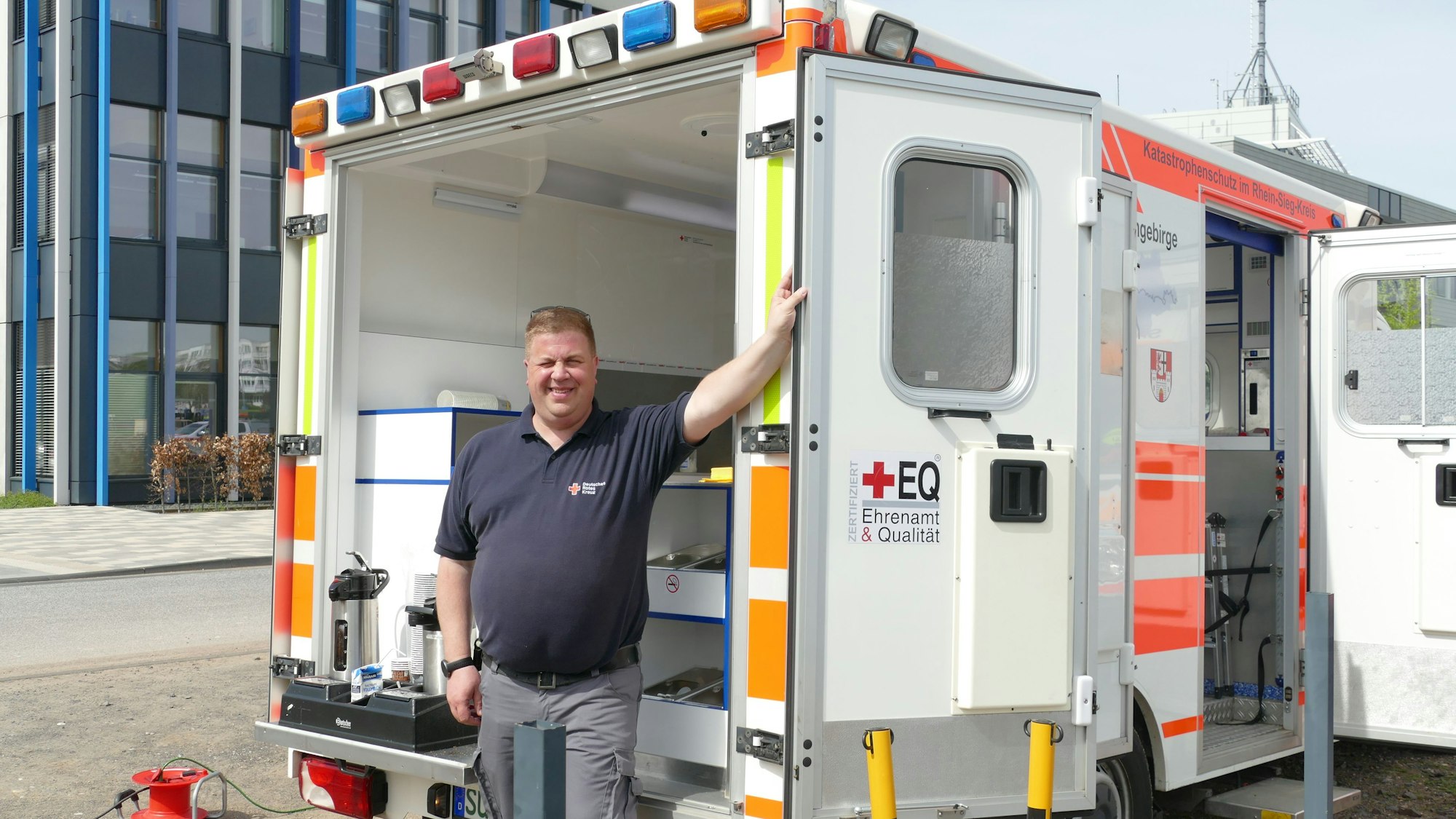 Ein Mann steht vor den geöffneten Türen eines Rettungswagens.