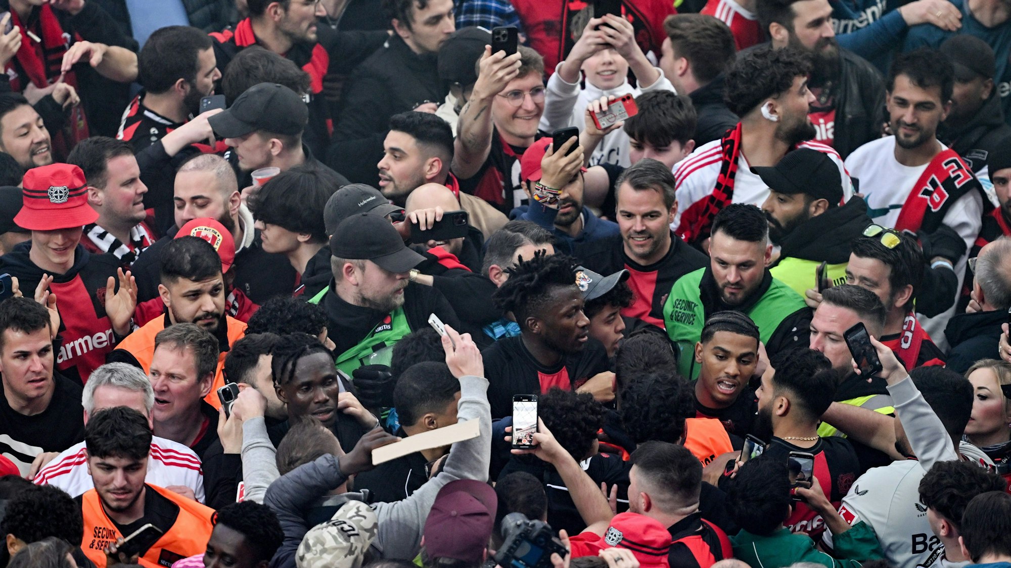 14.04.2024, Nordrhein-Westfalen, Leverkusen: Fußball: Bundesliga, Bayer 04 Leverkusen - SV Werder Bremen, 29. Spieltag, BayArena. Leverkusens Edmond Tapsoba (M) läuft an den Fans vorbei in die Kabine. Leverkusen gewinnt die Deutsche Meisterschaft.