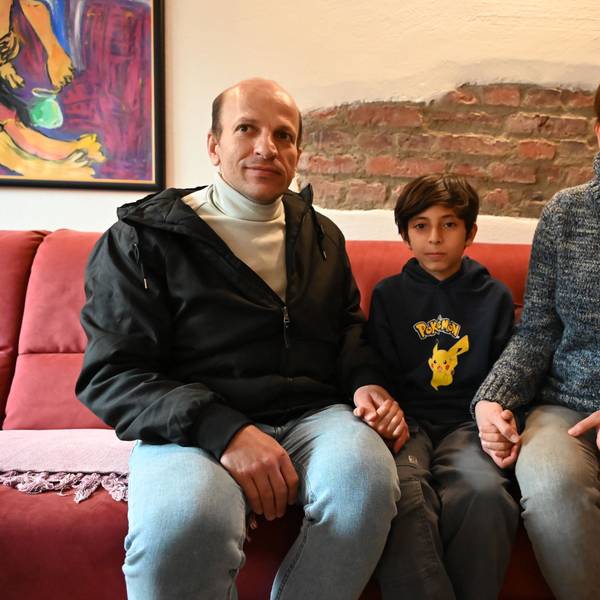 Das Bild zeigt die iranische Familie. Sie sitzen auf einem roten Sofa.