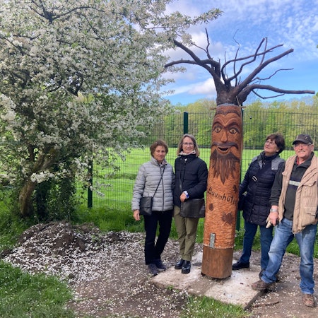 Ehrenamtliche planen einen Walderlebnispfad auf Gut Leidenhausen, ein Waldgeist aus Holz lädt dazu ein.