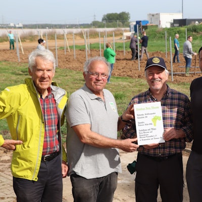 Das Bild zeigt mehrere Personen vor dem neuen Weinberg