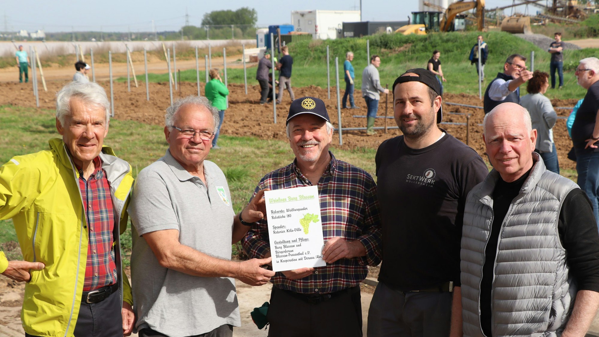Das Bild zeigt mehrere Personen vor dem neuen Weinberg