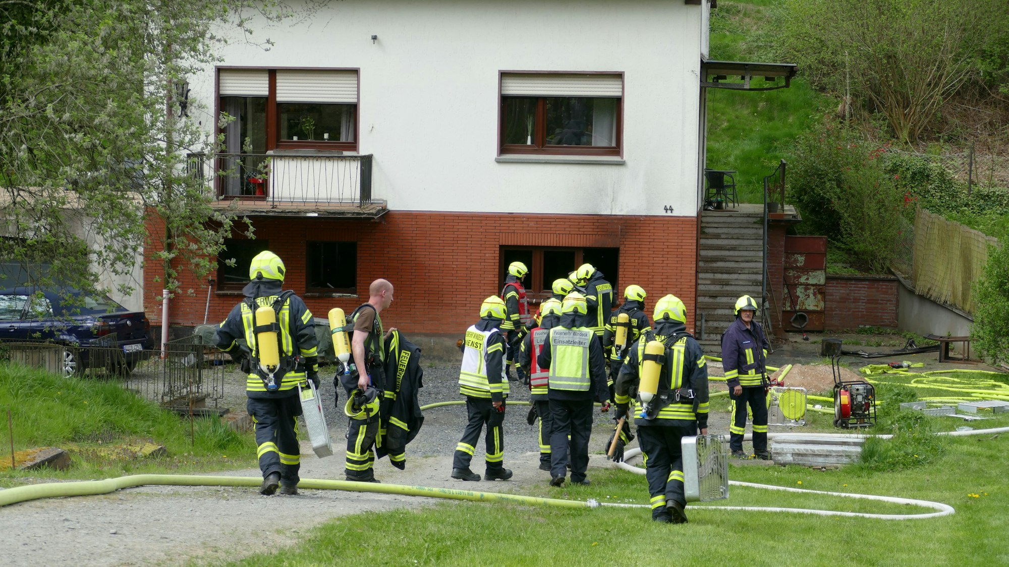 Feuerwehrleute stehen vor dem betroffenen Haus.