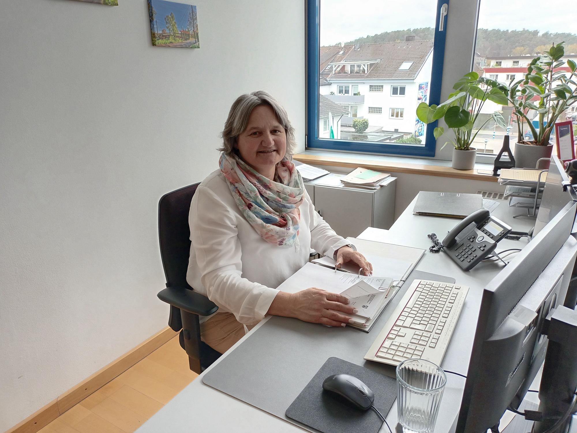 Eine Frau blättert in einem Büro in einer Akte