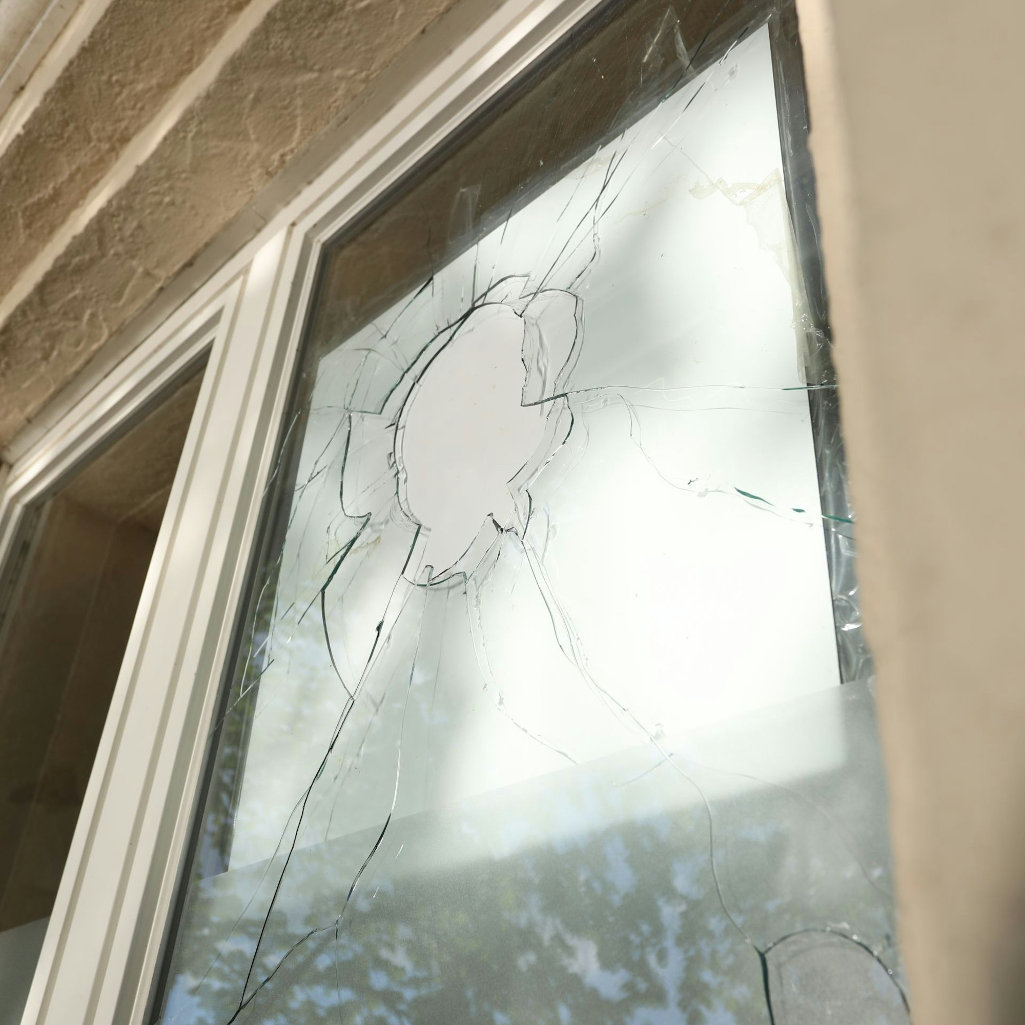 Eine Fensterscheibe mit einem Loch und Rissen.