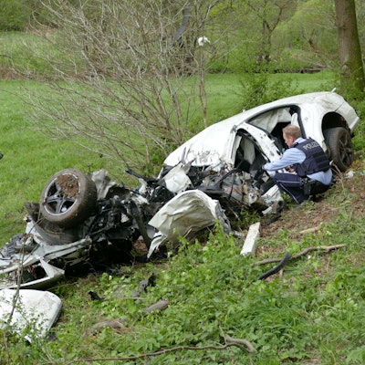 Polizeibeamte untersuchen das Unfallwrack in Much.
