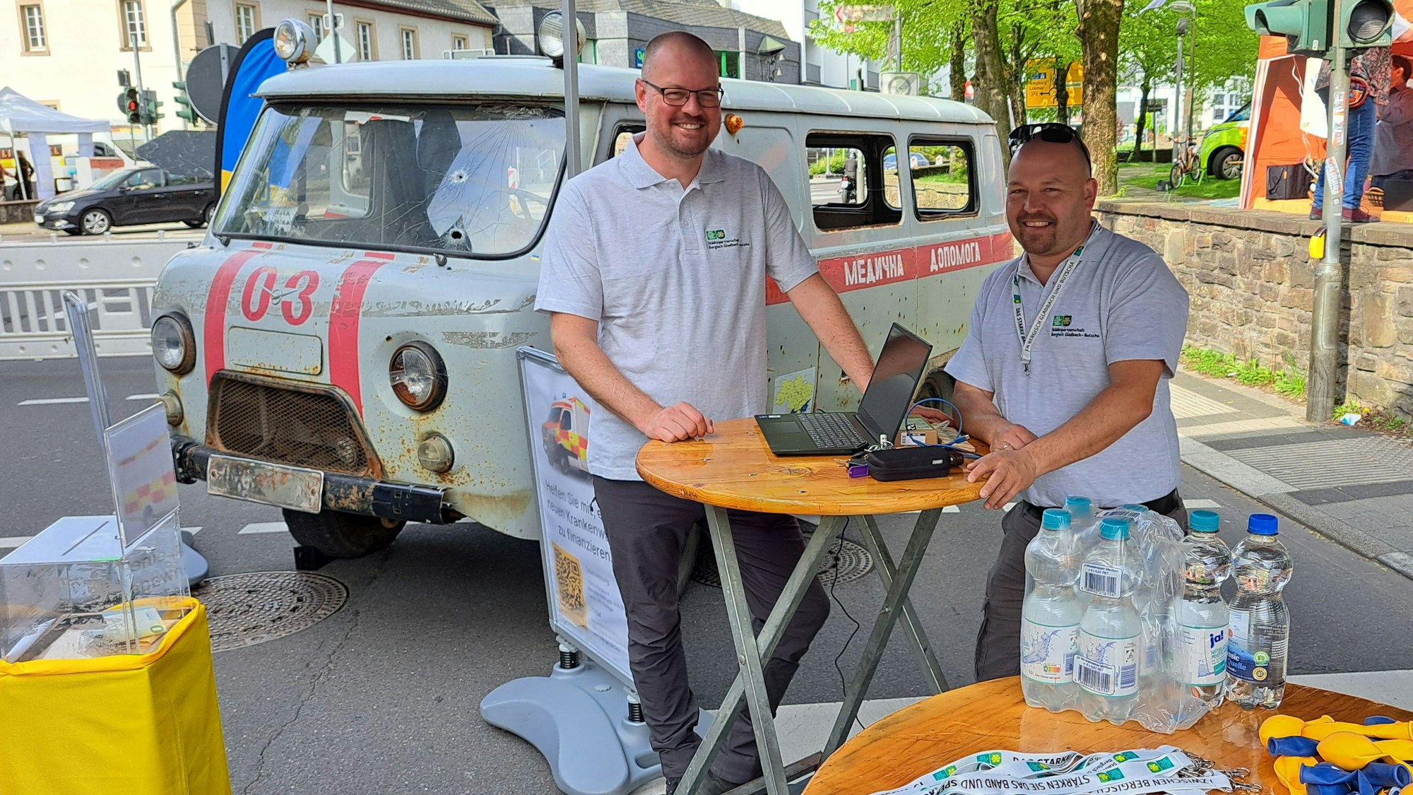 Niklas Habers (l.) und Christian Fischer vom Partnerschaftsverein Bergisch Gladbach - Butscha mit dem beschossenen ukrainischen Krankenwagen auf dem Overather Frühling.