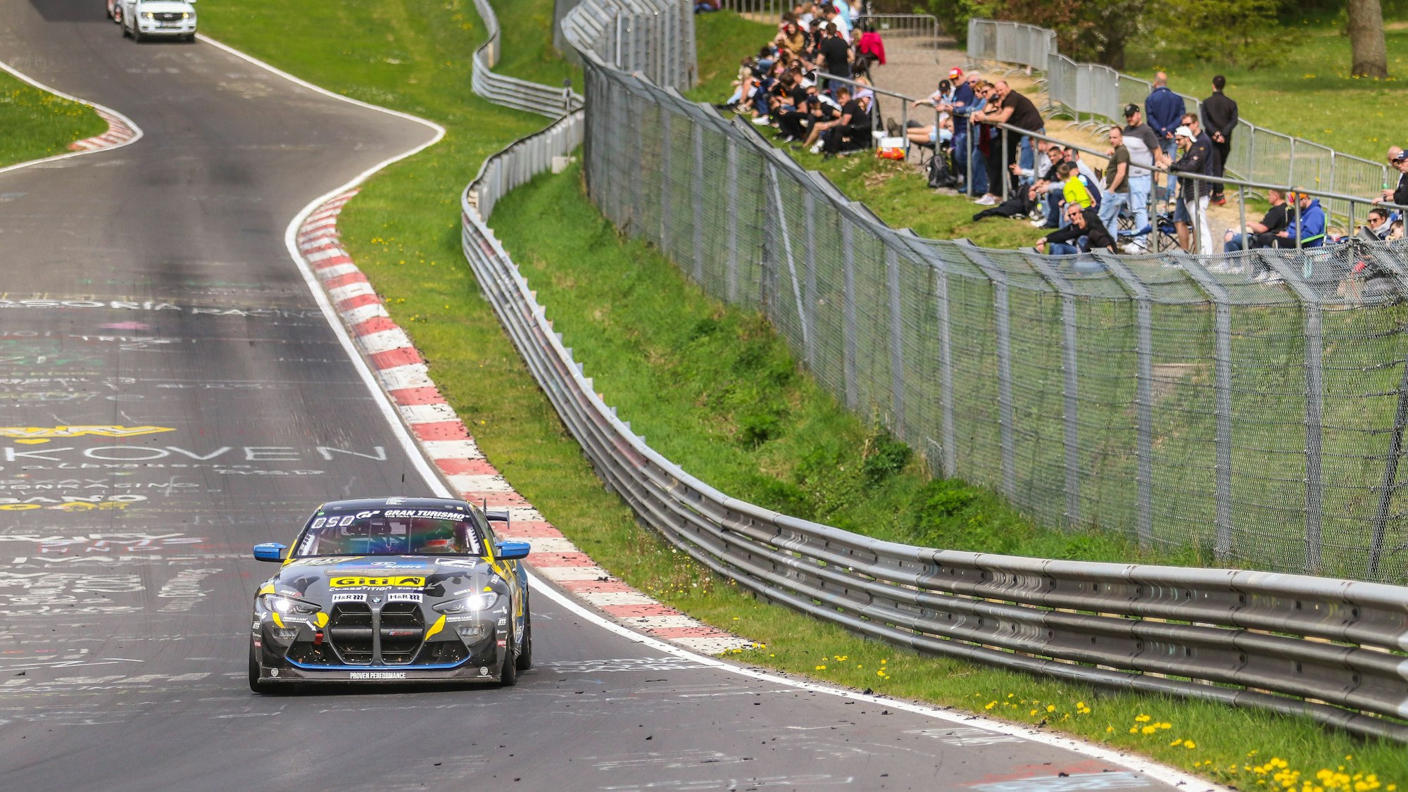 Carrie Schreiner fährt im BMW an den Zuschauerrängen vorbei.