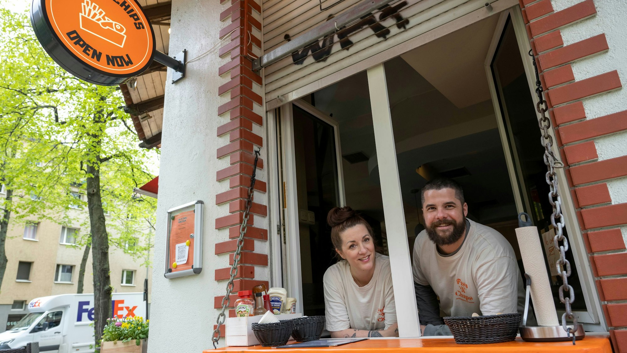 Ein Mann und eine Frau schauen aus einem Fenster heraus.