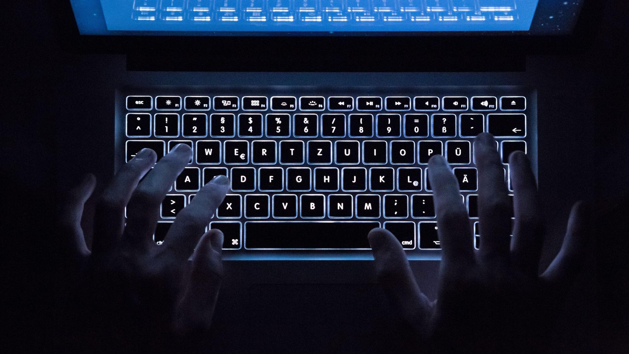 Eine Person benutzt die beleuchtete Tastatur eines Notebooks. (Symbolbild)