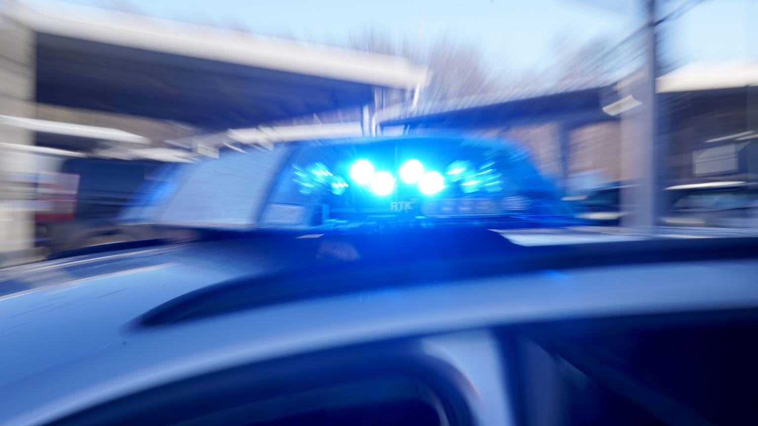 Ein Polizeiauto fährt mit Blaulicht.