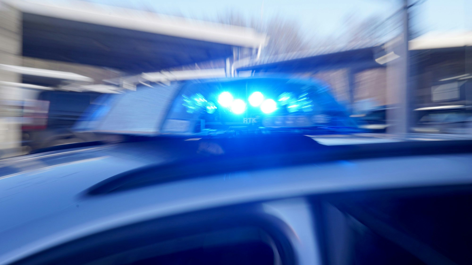 Ein Polizeiauto fährt mit Blaulicht.