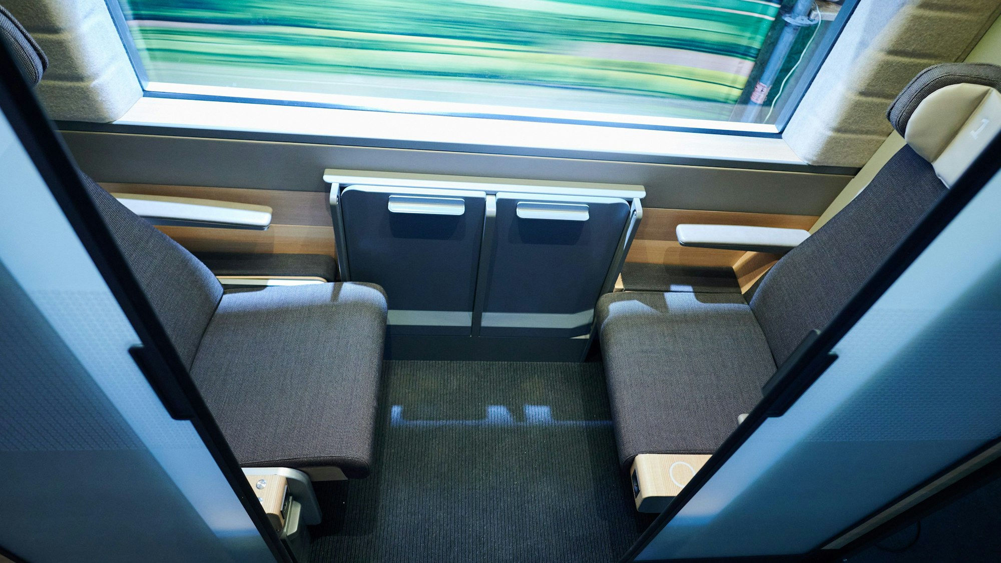 In den neuen Zweierabteilen der Deutschen Bahn sitzen sich Personen gegenüber, die Milchglasscheibe kann auf Knopfdruck mehr Sichtschutz bieten.