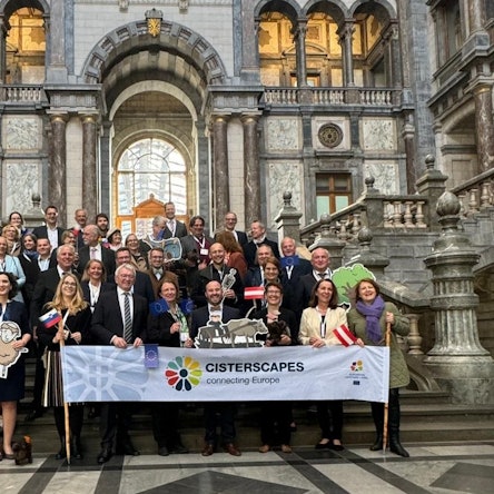 Zahlreiche Menschen stehen auf den Stufen eines palastartigen Gebäudes. Davor ein Banner mit der Aufschrift Cisterscapes.