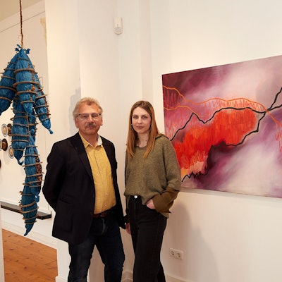 Axel und Wibke Müller stehen im Kuba, hinter ihnen sind ein Bild und eine Plastik zu sehen.