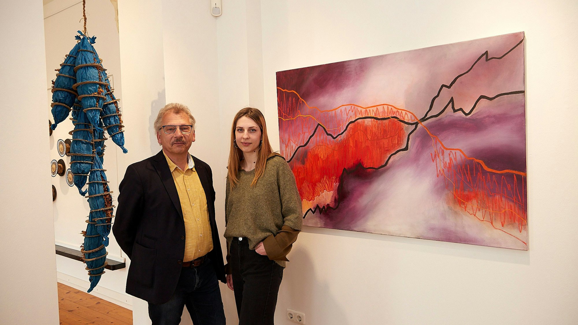 Axel und Wibke Müller stehen im Kuba, hinter ihnen sind ein Bild und eine Plastik zu sehen.