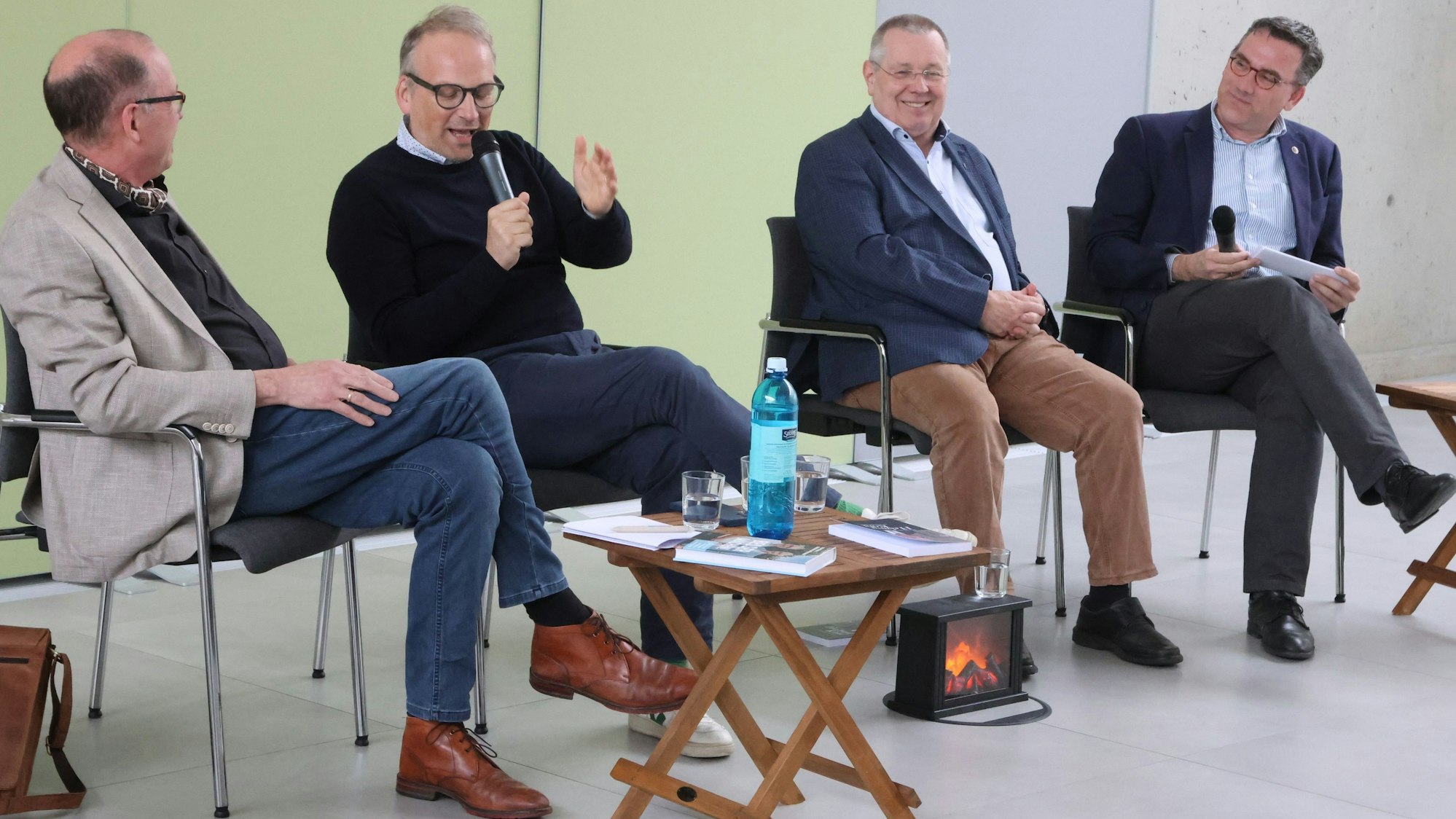 An einer elektrischen Feuerstelle nahmen im Waldbröler Bürgerdorf am Alsberg zu einem „Kamingespräch“ Platz (von links): Uwe Bathe, Christoph Waffenschmidt, Stephan Eisel und Marcus Dräger. Unser Foto zeigt die Männerrunde in der Diskussion.