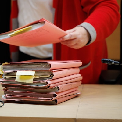 Blick auf einen Stapel Prozessakten im Sitzungssaal im Landgericht Bielefeld.