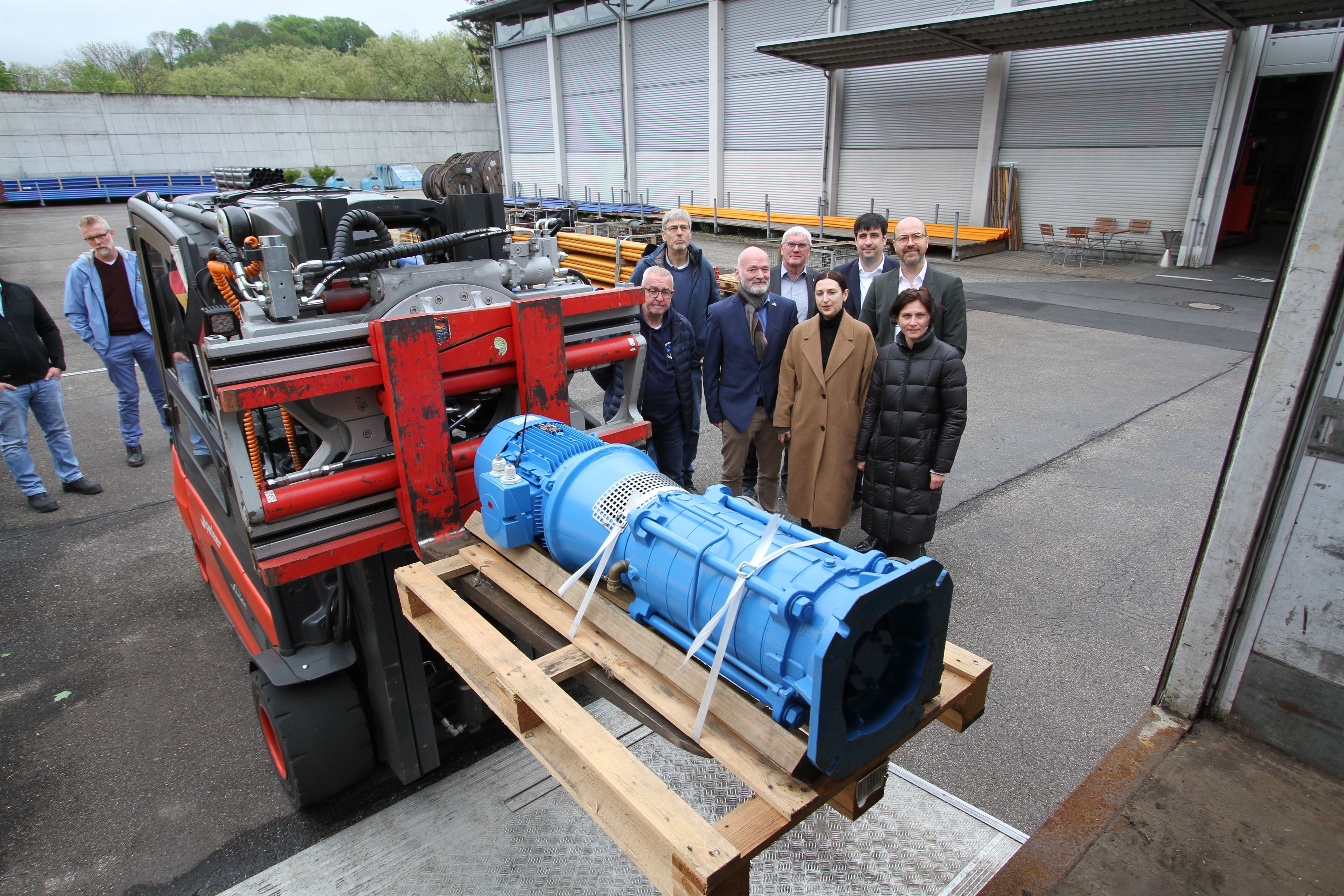 Ein Gabelstapler lädt eine blau lackierte Pumpe in einen Lastwagen