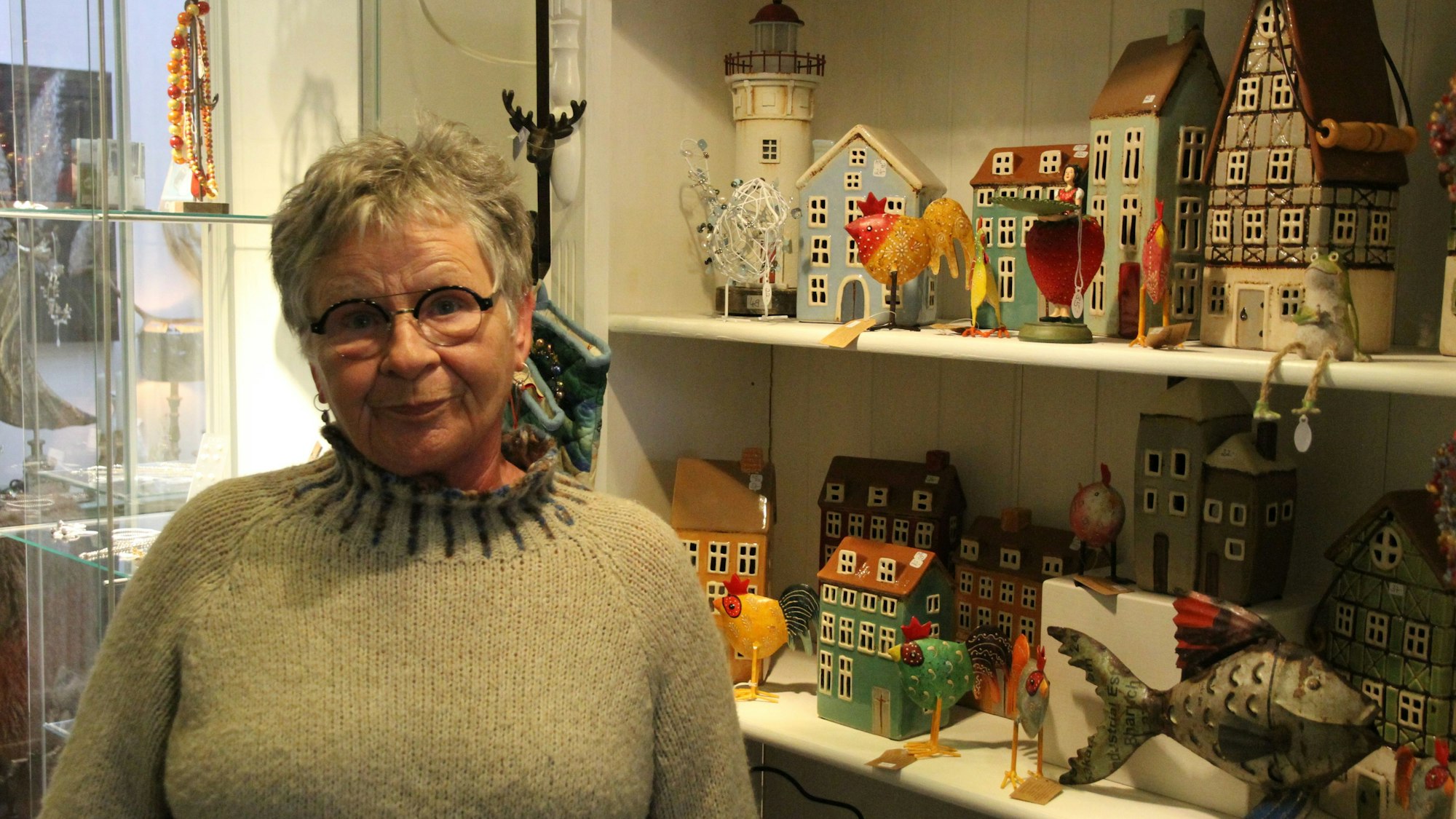 Eine Frau vor einem Regal mit Deko-Häuschen