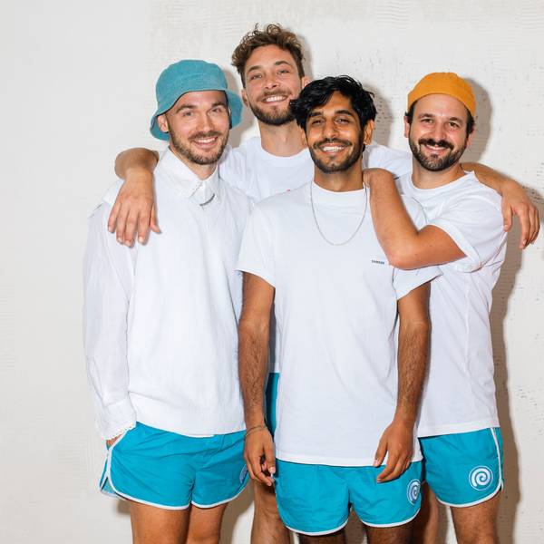 Die vier Bandmitglieder stehen zusammen und grinsen in die Kamera.