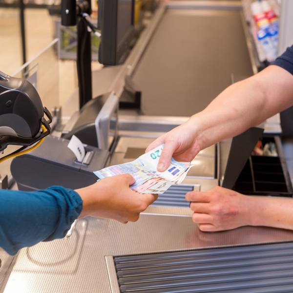 In einem Supermarkt hebt eine Kundin beim Bezahlen auch gleich Bargeld ab.