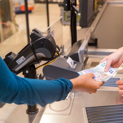 In einem Supermarkt hebt eine Kundin beim Bezahlen auch gleich Bargeld ab.