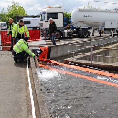 Besucher des Thementages Hochwasser/Flut schauen sich im Außengelände von Jola-Rent mobile Hochwasserschutzsysteme an.