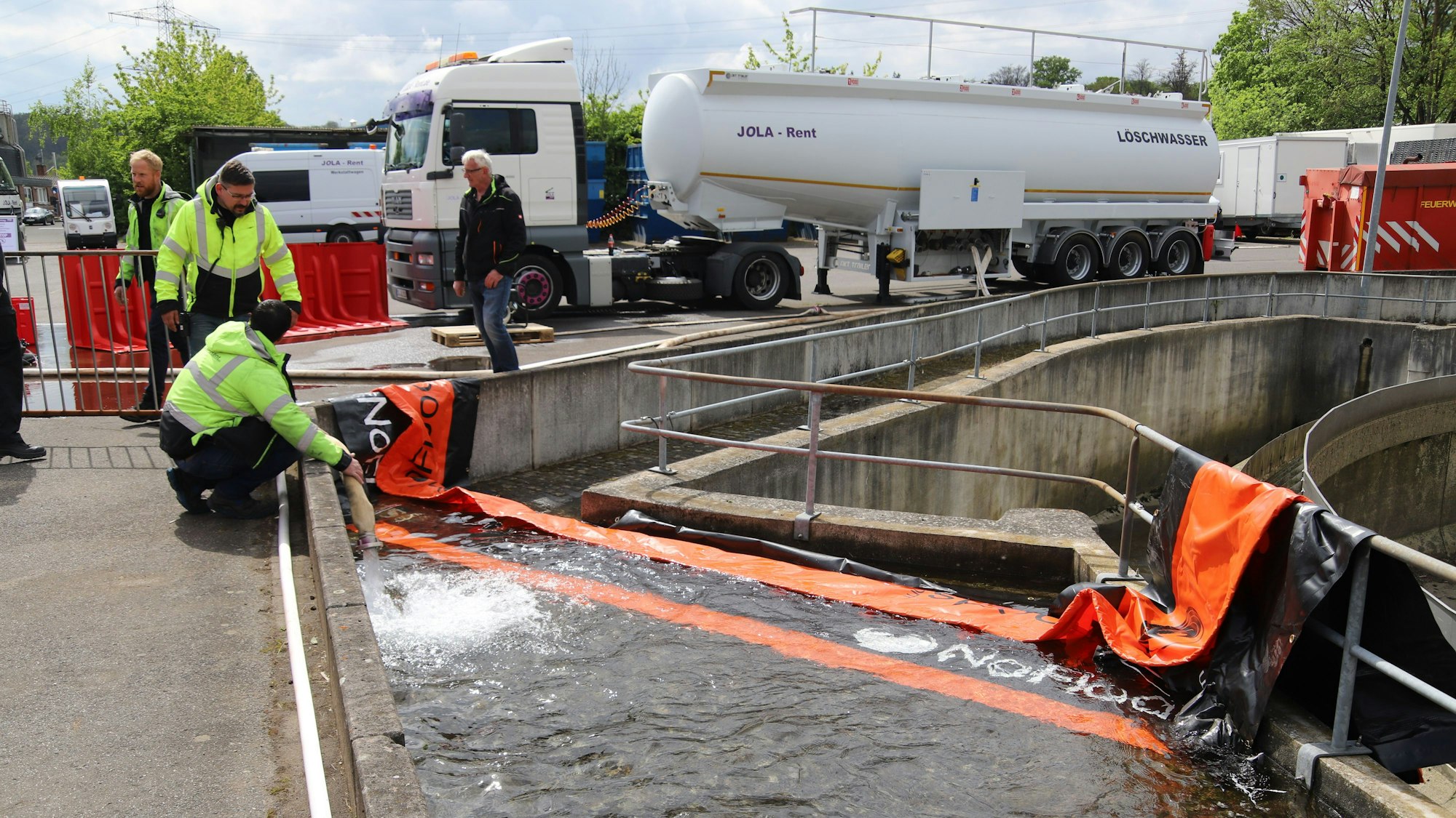 Besucher des Thementages Hochwasser/Flut schauen sich im Außengelände von Jola-Rent mobile Hochwasserschutzsysteme an.