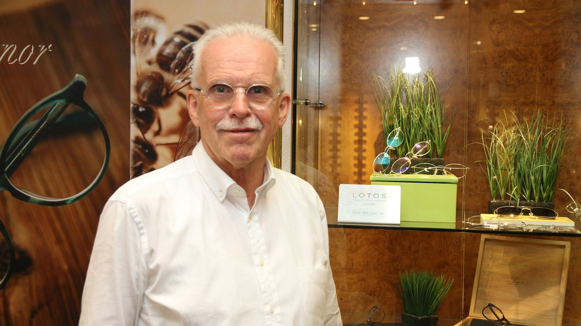 Ein Mann vor einer Vitrine mit Brillen