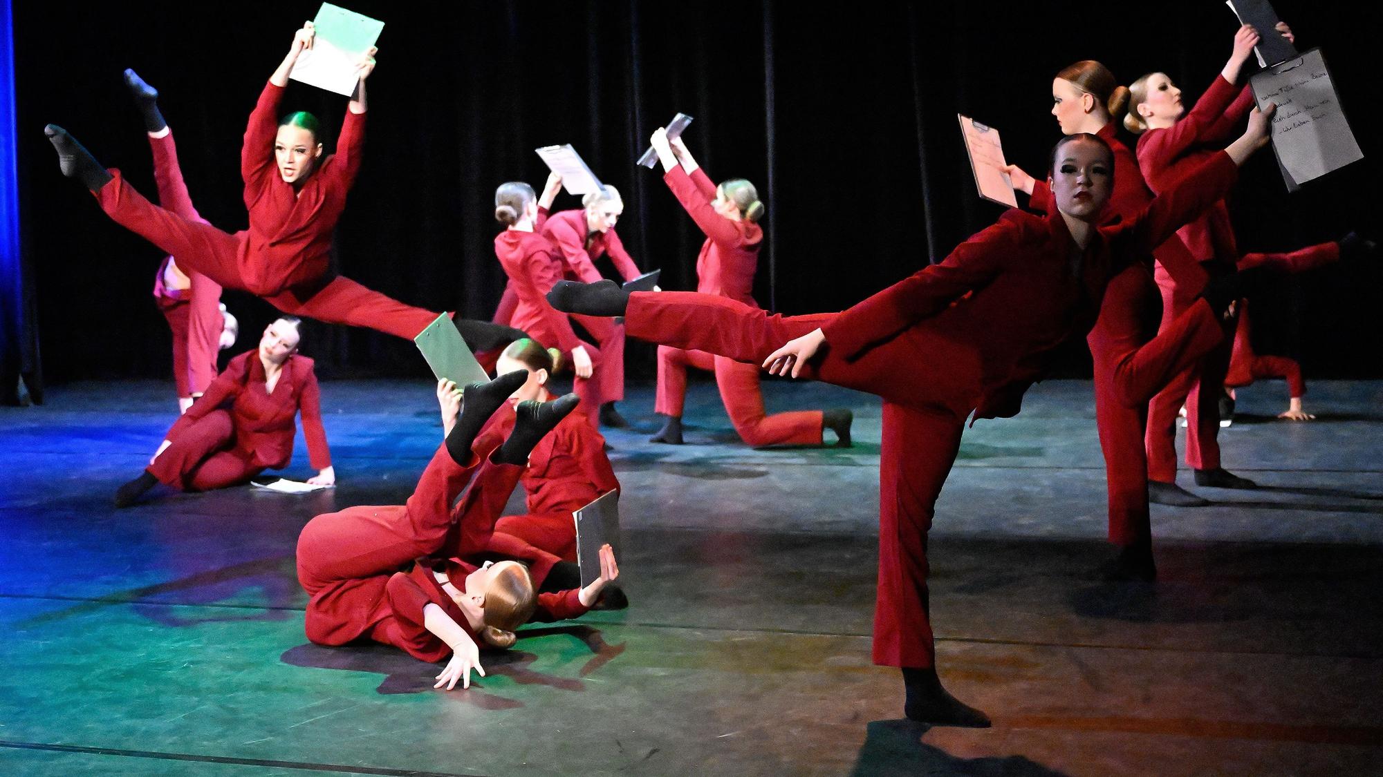 Tänzerinnen der Dancin' Midis tanzen mit Klemmbrettern über die Bühne des Bergischen Löwen in Bergisch Gladbach.