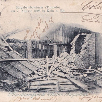 Eine Postkarte zeigt das Foto eines eingestürzten Hauses, daneben handschriftliche Anmerkungen.