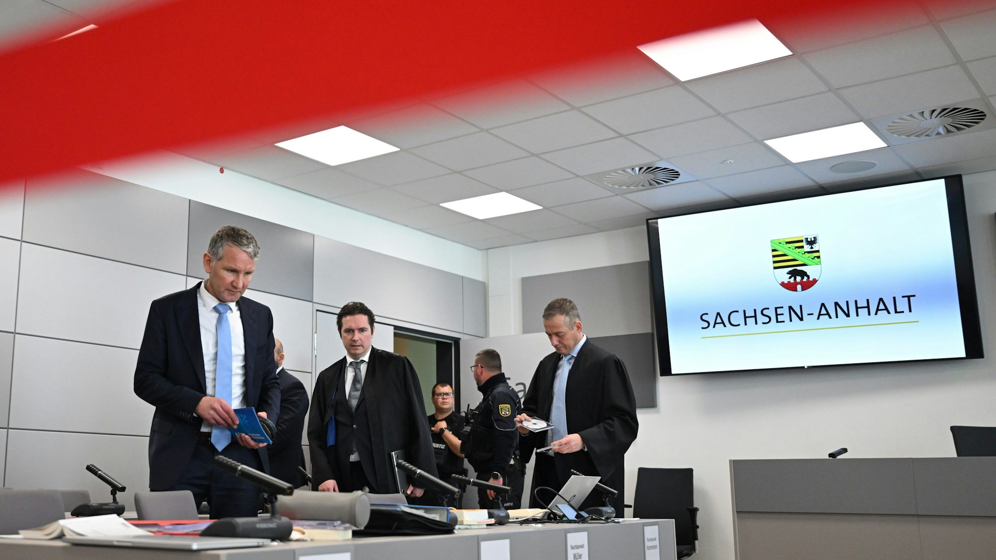 Björn Höcke (l), steht zum Ende der Pause im Gerichtssaal im Landgericht Halle.