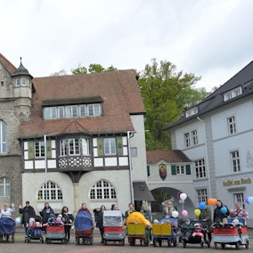Tagesmütter mit Kinderwagen und Kindern an der Hand stehen vor dem Rathaus in Bergisch Gladbach.