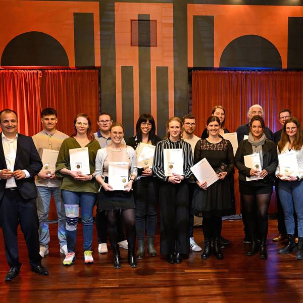 Menschen schauen mit Urkunden in die Kamera bei der Jugendbetreuerehrung im Spiegelsaal des Bergischen Löwen.
