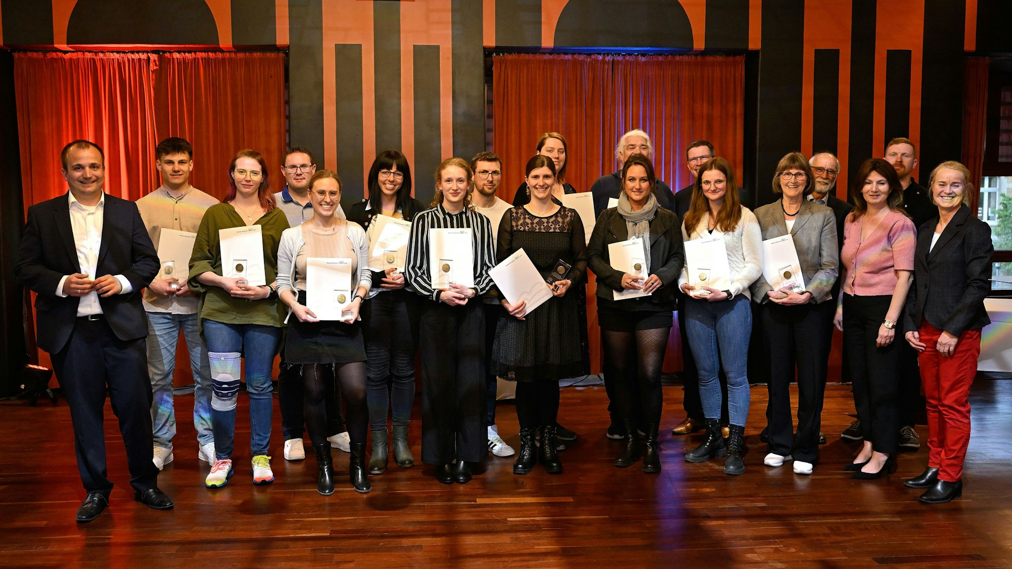 Menschen schauen mit Urkunden in die Kamera bei der Jugendbetreuerehrung im Spiegelsaal des Bergischen Löwen.