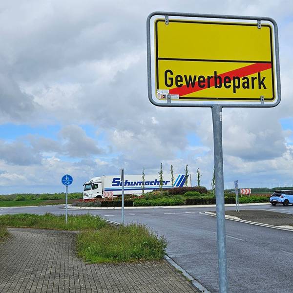 Zu sehen ist ein Ortsausgangsschild und ein Verkehrskreisel.