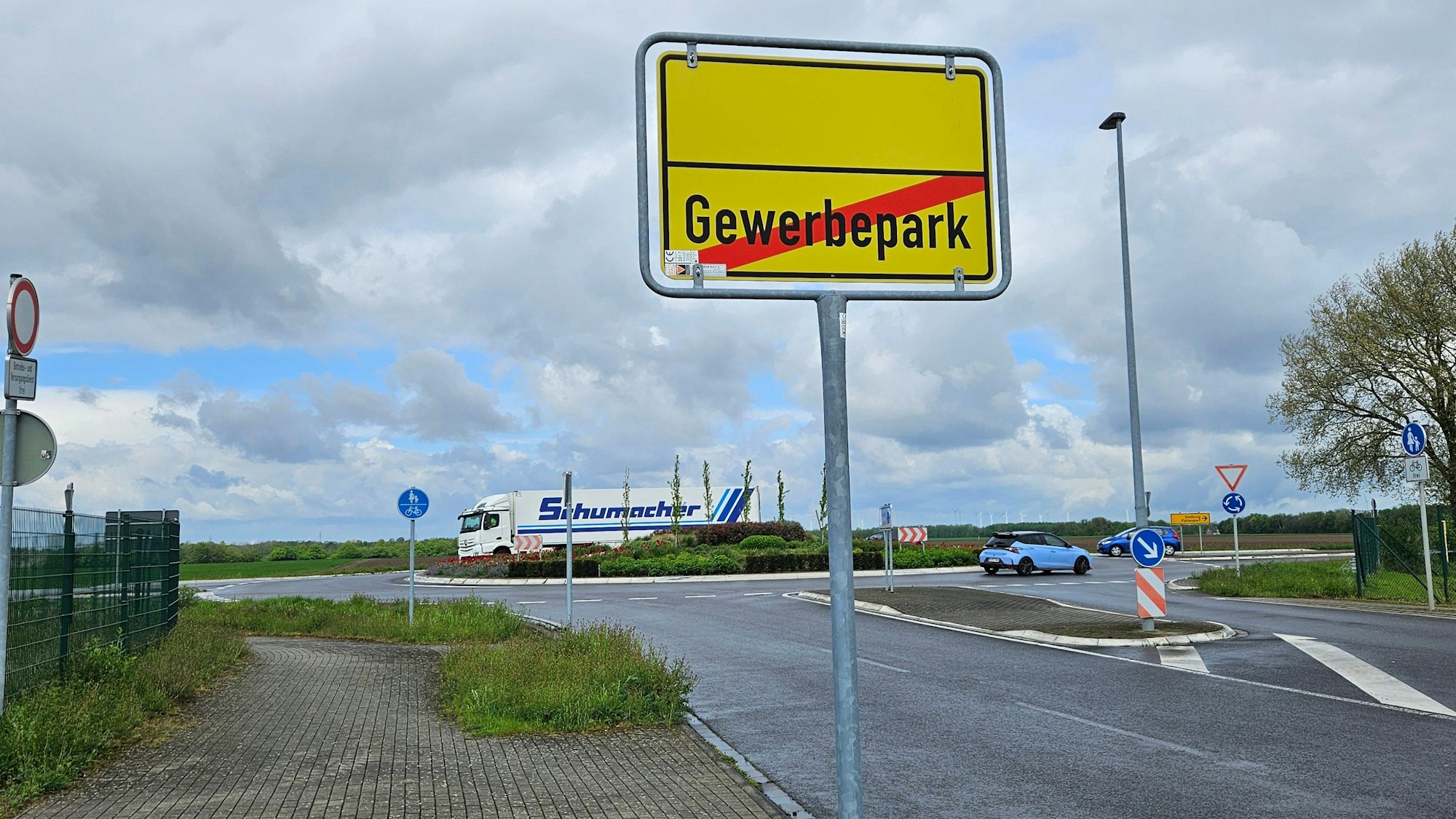 Zu sehen ist ein Ortsausgangsschild und ein Verkehrskreisel.